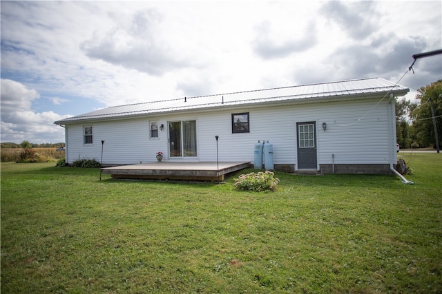 rear view of property with a yard and a wooden deck