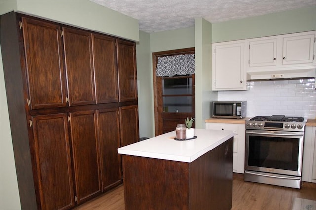 983 Vernon Rd, West Salem Twp, PA 16125 - kitchen with under cabinet range hood, wood finished floors, light countertops, white cabinets, and appliances with stainless steel finishes