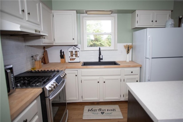 983 Vernon Rd, West Salem Twp, PA 16125 - kitchen with a sink, freestanding refrigerator, stainless steel gas stove, white cabinets, and under cabinet range hood