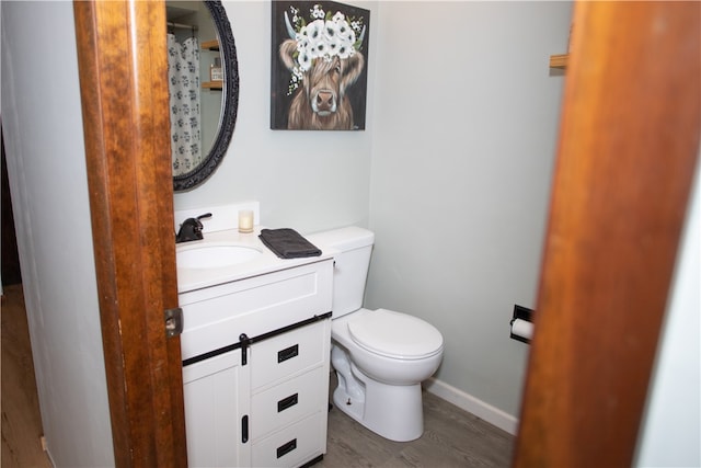 bathroom with vanity, toilet, and hardwood / wood-style flooring