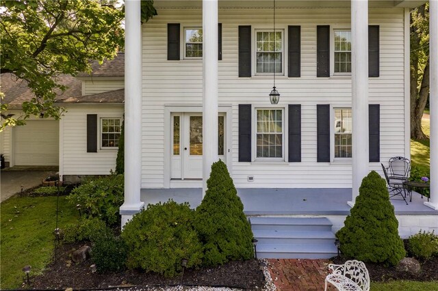 123 Leech Rd, Hempfield Twp Mer, PA 16125 - greek revival house featuring a porch, an attached garage, roof with shingles, and concrete driveway