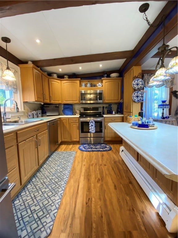 kitchen featuring a wealth of natural light, hanging light fixtures, appliances with stainless steel finishes, and a baseboard radiator