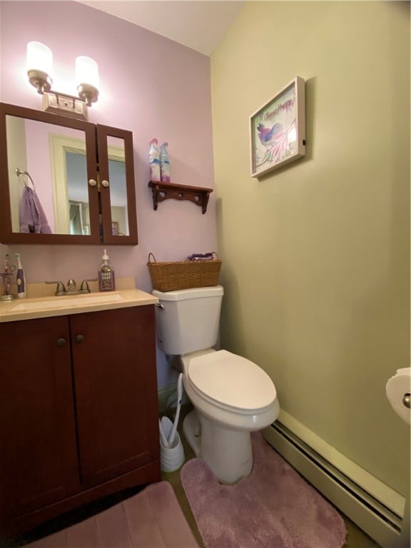 bathroom featuring vanity, toilet, and a baseboard heating unit