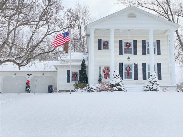 greek revival inspired property with a garage