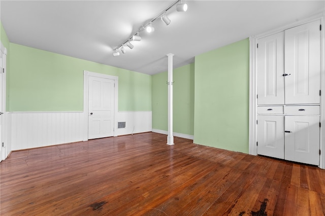 interior space with rail lighting and dark wood-type flooring