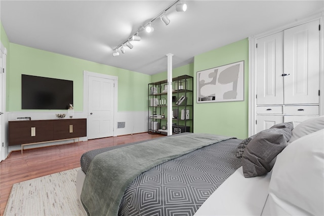 bedroom with light wood-type flooring and rail lighting