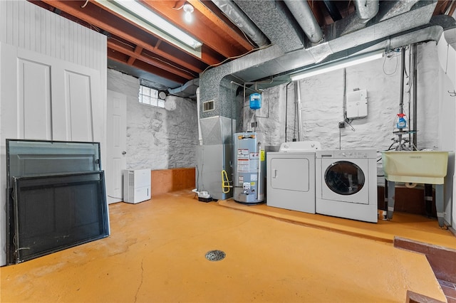 basement featuring gas water heater, sink, and independent washer and dryer