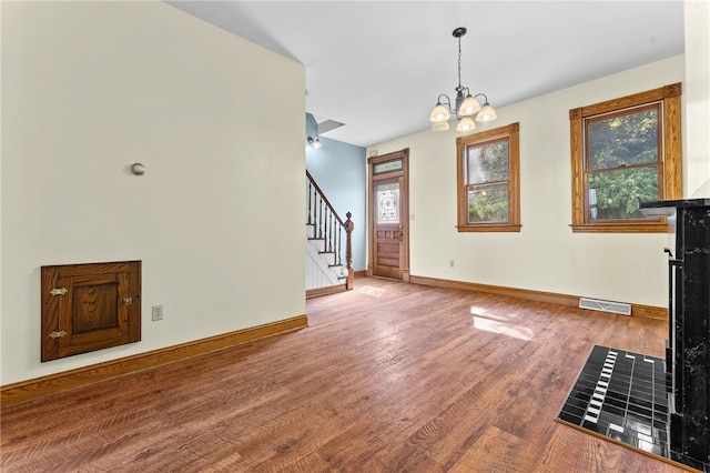 unfurnished living room featuring a chandelier and hardwood / wood-style flooring