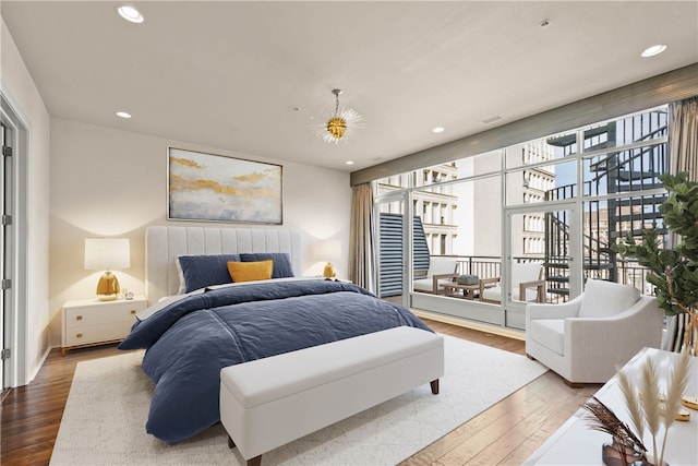 bedroom featuring wood-type flooring and access to outside