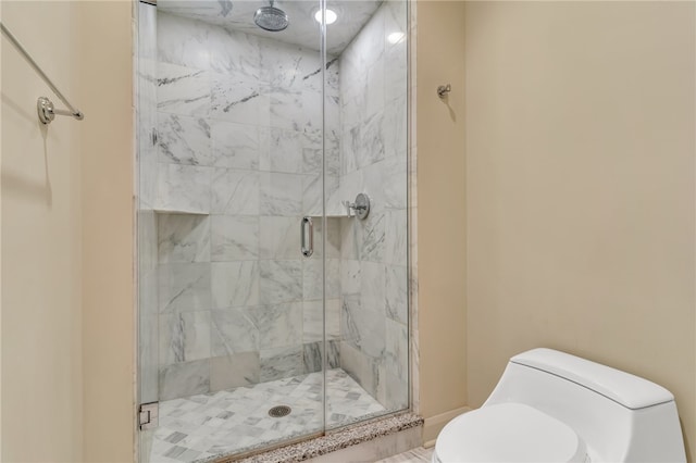 bathroom with a shower with shower door and toilet