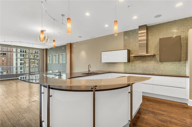 kitchen featuring wall chimney exhaust hood, white cabinets, and dark hardwood / wood-style flooring