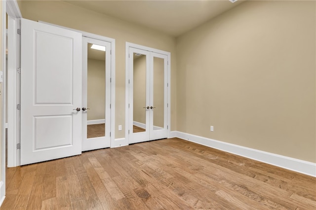 unfurnished bedroom featuring french doors and light hardwood / wood-style floors