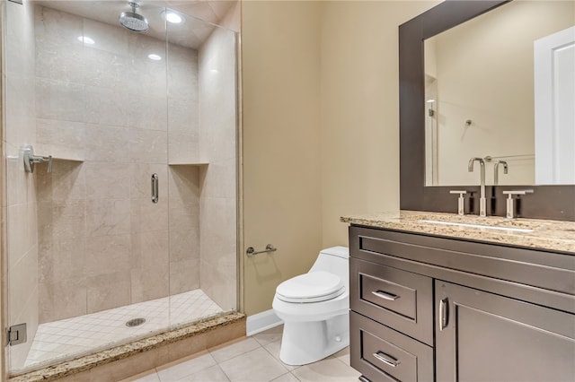 bathroom with vanity, toilet, a shower with door, and tile patterned floors