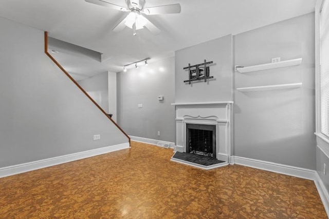 unfurnished living room with ceiling fan and rail lighting