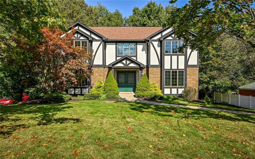 tudor home featuring a front yard