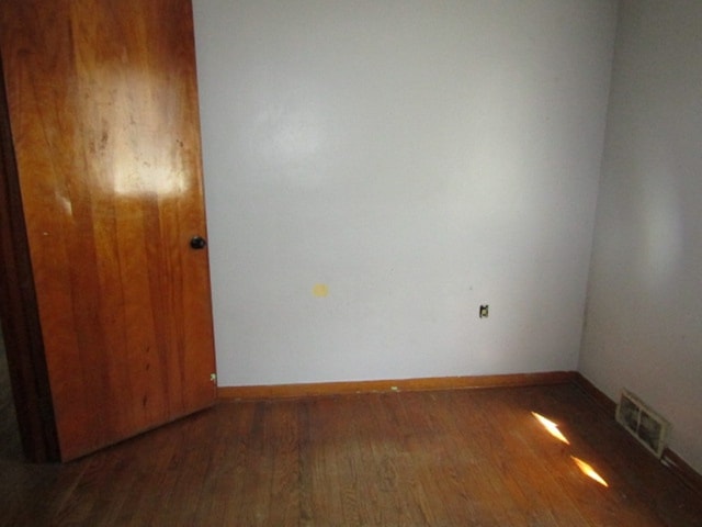 spare room featuring dark wood-type flooring