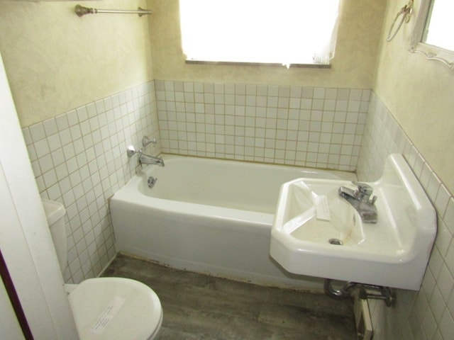 bathroom with plenty of natural light, toilet, and a washtub