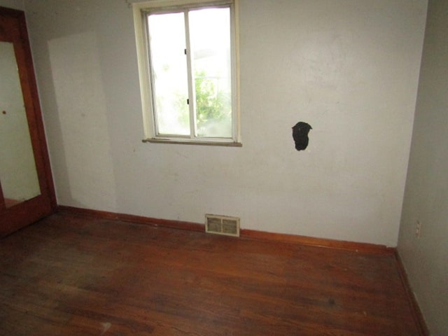 unfurnished room with dark wood-type flooring