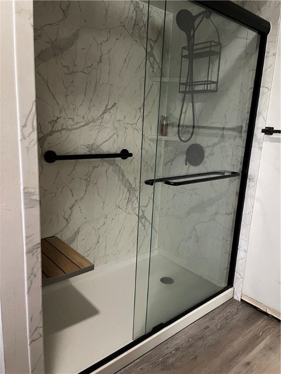 bathroom featuring wood-type flooring and an enclosed shower