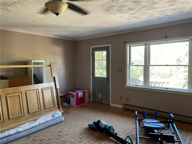 exercise room featuring wood-type flooring, crown molding, and ceiling fan