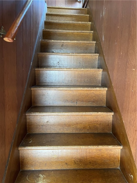 stairs featuring wood walls