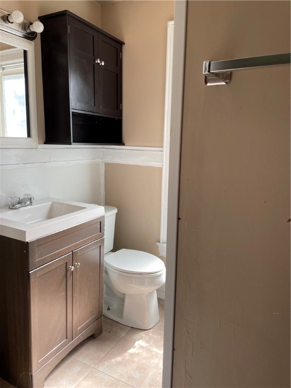 bathroom with vanity, tile patterned flooring, and toilet