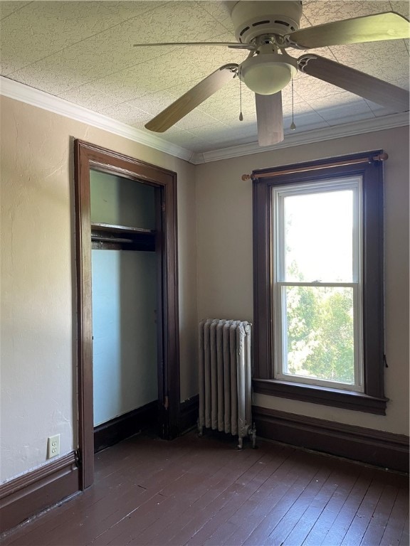 unfurnished bedroom featuring wood-type flooring, ornamental molding, ceiling fan, and radiator heating unit