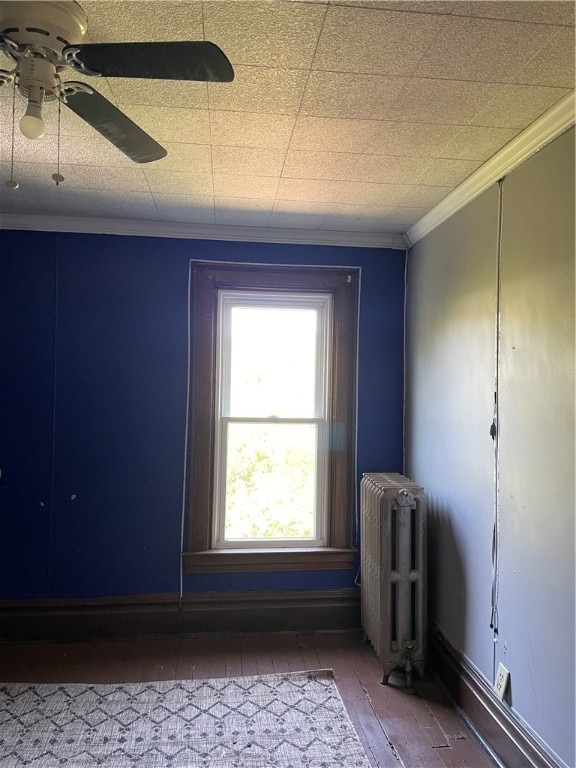 unfurnished room with ceiling fan, radiator, ornamental molding, and hardwood / wood-style floors