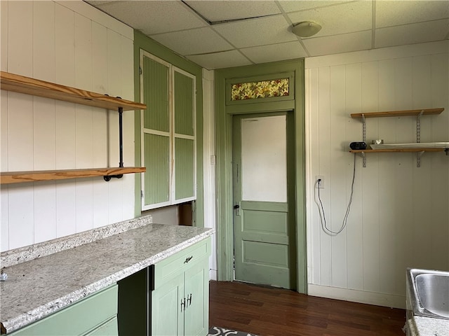 kitchen featuring a drop ceiling, wood walls, and dark hardwood / wood-style floors