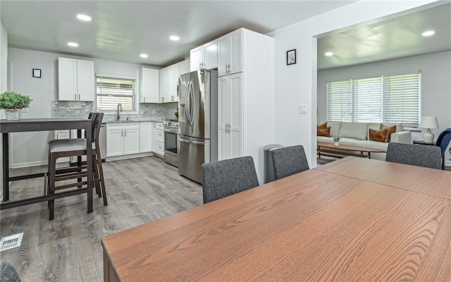 dining space featuring light hardwood / wood-style floors and sink