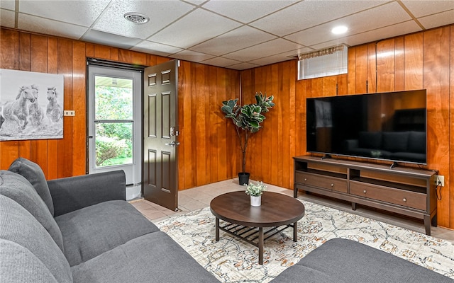 tiled living room with a drop ceiling and wooden walls