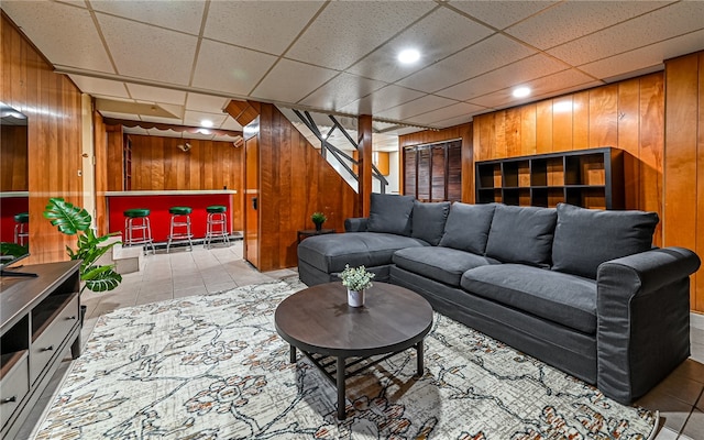 tiled living room with wooden walls and a paneled ceiling