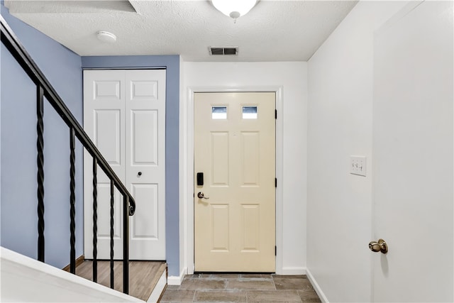 entrance foyer featuring light hardwood / wood-style floors and a textured ceiling