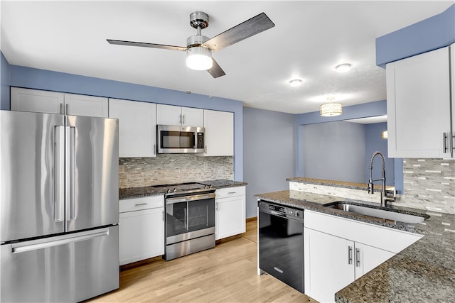 kitchen featuring sink, white cabinets, stainless steel appliances, dark stone countertops, and ceiling fan