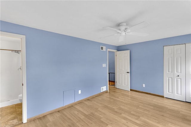 unfurnished bedroom featuring ceiling fan, light wood-type flooring, and ensuite bathroom