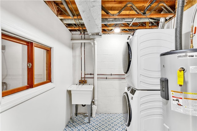 interior space with electric water heater, sink, and stacked washing maching and dryer