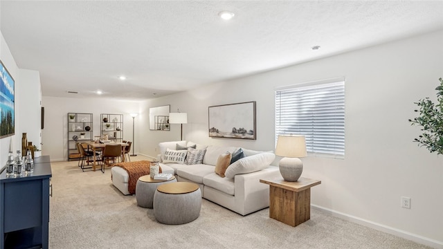 carpeted living room featuring a textured ceiling