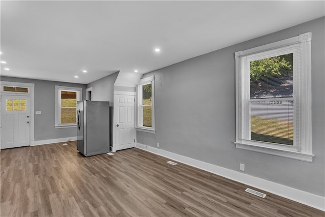 unfurnished living room with light wood-type flooring and a healthy amount of sunlight