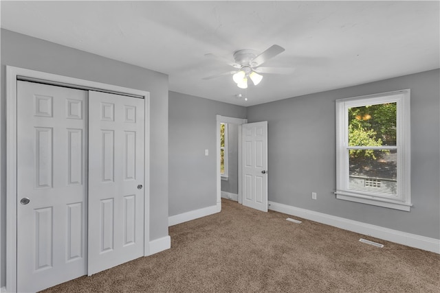 unfurnished bedroom with ceiling fan, carpet floors, and a closet