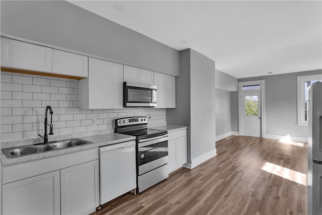 kitchen with light hardwood / wood-style flooring, appliances with stainless steel finishes, sink, and white cabinetry