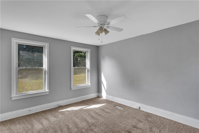 empty room featuring ceiling fan and carpet