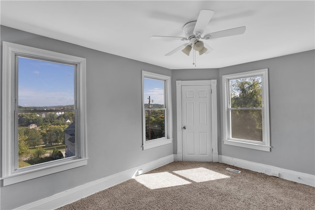 carpeted empty room featuring ceiling fan