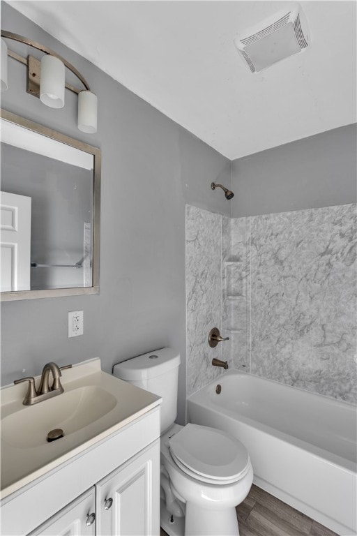 full bathroom featuring washtub / shower combination, hardwood / wood-style floors, vanity, and toilet