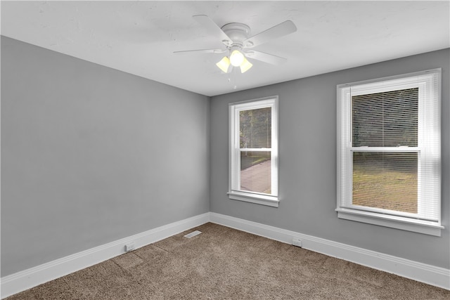 spare room featuring ceiling fan and carpet