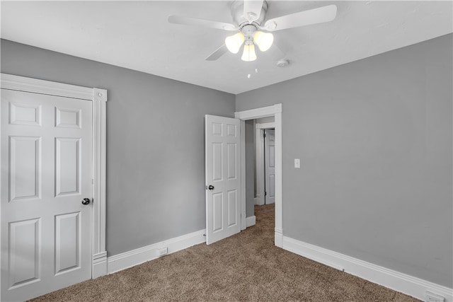 unfurnished bedroom featuring ceiling fan and carpet flooring