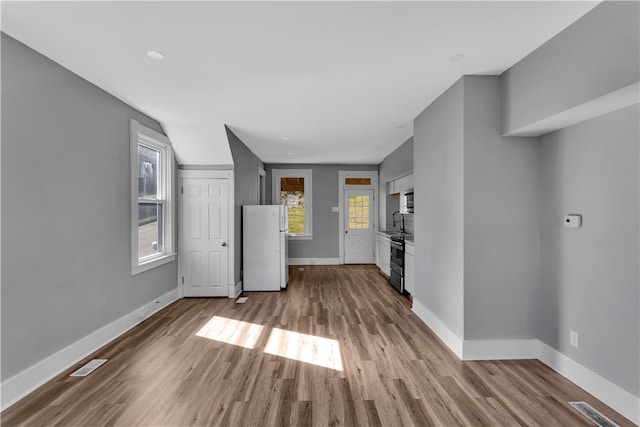 interior space with appliances with stainless steel finishes and light hardwood / wood-style flooring