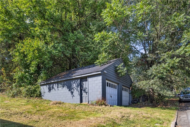 view of outdoor structure with a lawn and a garage