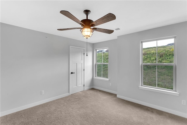 carpeted spare room with ceiling fan