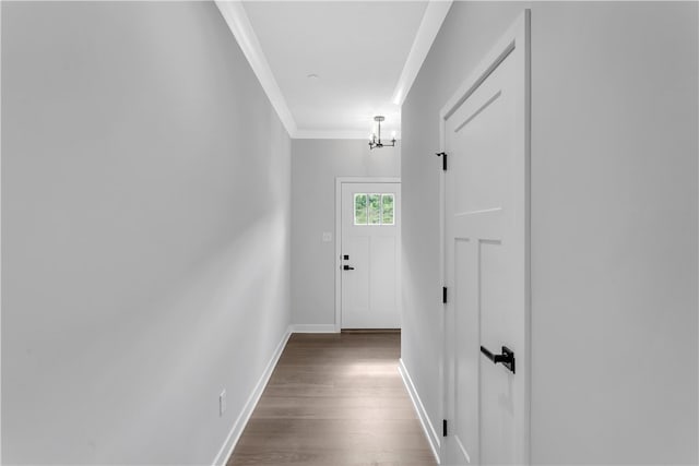 corridor featuring dark hardwood / wood-style floors, a chandelier, and crown molding