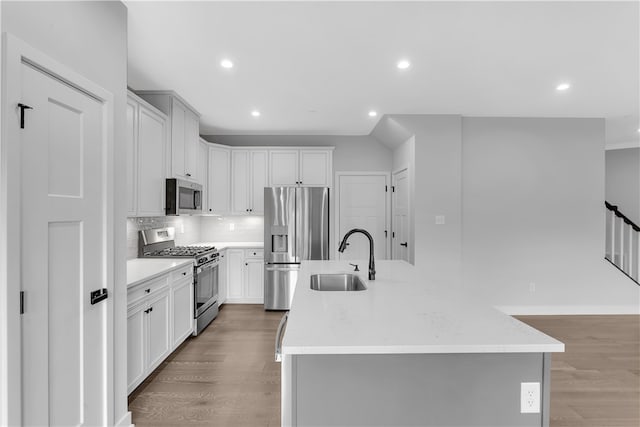 kitchen with light hardwood / wood-style floors, a center island with sink, appliances with stainless steel finishes, and sink